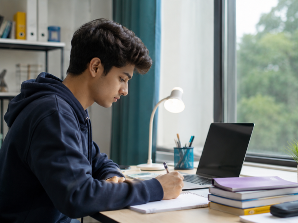 Young student or entry-level job seeker working independently on a laptop in a quiet study environment, representing beginner-friendly careers for introverts.
