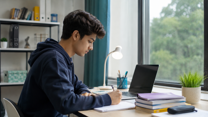 Young student or entry-level job seeker working independently on a laptop in a quiet study environment, representing beginner-friendly careers for introverts.