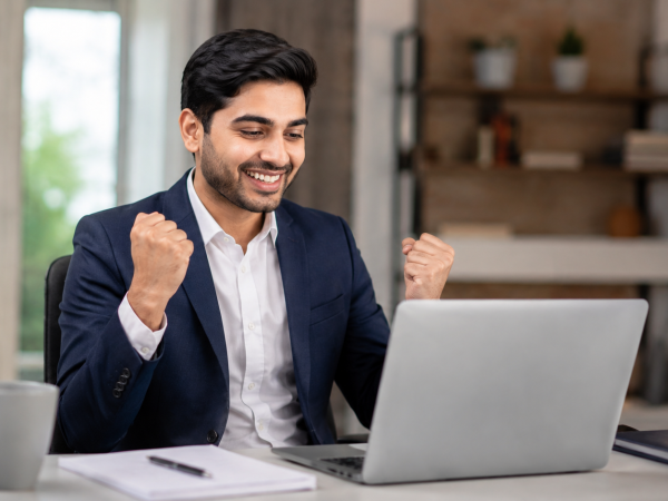 Young job seeker confidently preparing for a job interview on a laptop in a modern office environment.
