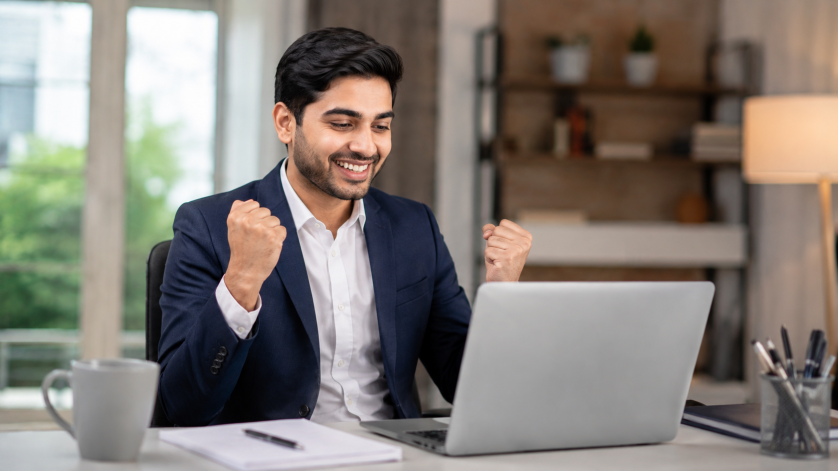 Young job seeker confidently preparing for a job interview on a laptop in a modern office environment.